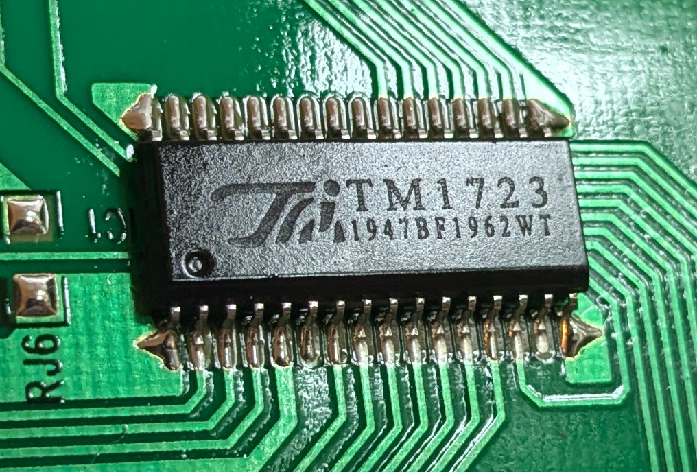 An integrated circuit is shown, labeled “TM1723” and “1947BF1962WT”. It is attached to a circuit board.