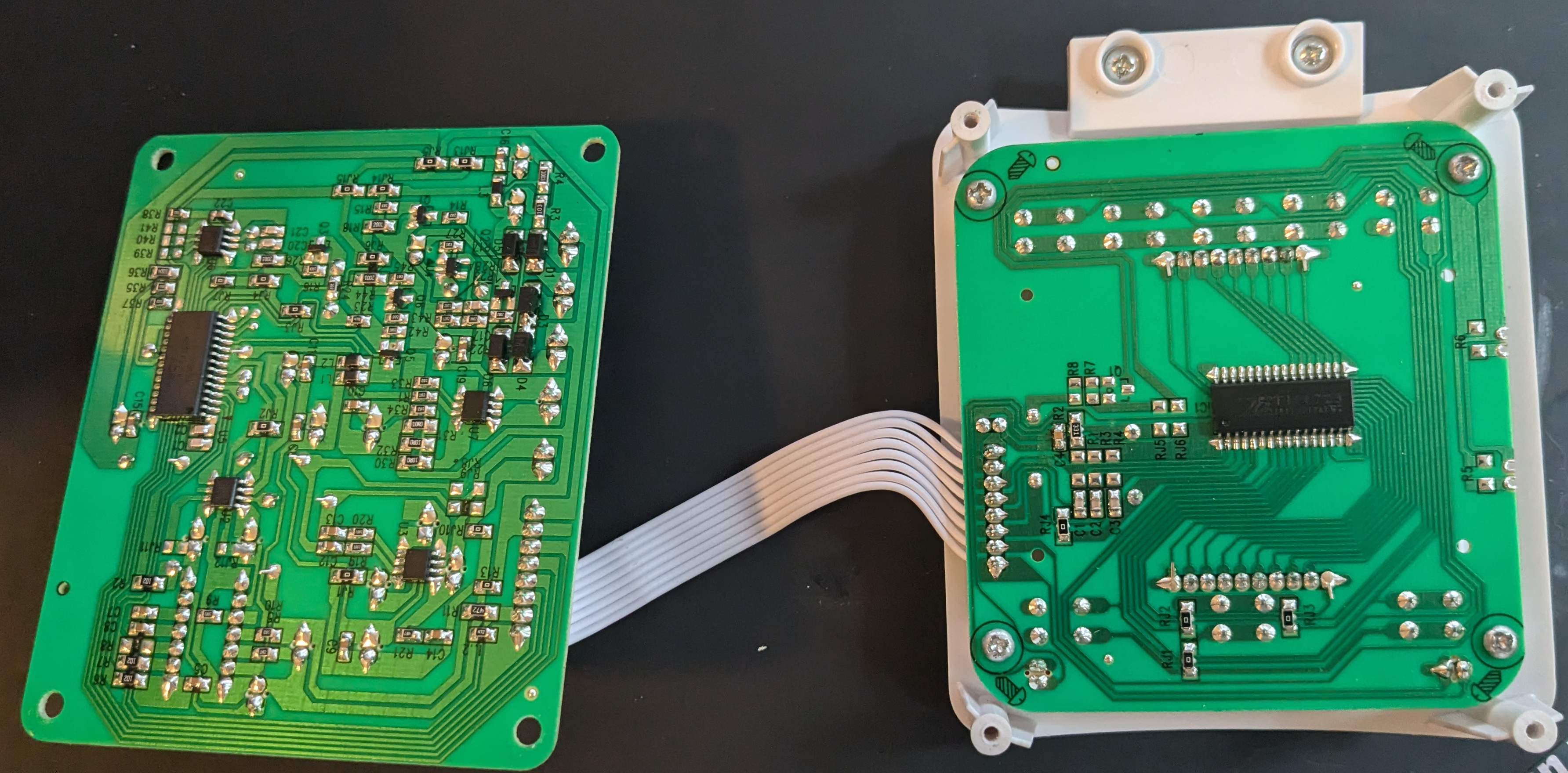 Two circuit boards are shown side-by-side. We can see traces, labels, and one IC on each half, but cannot read the labels.